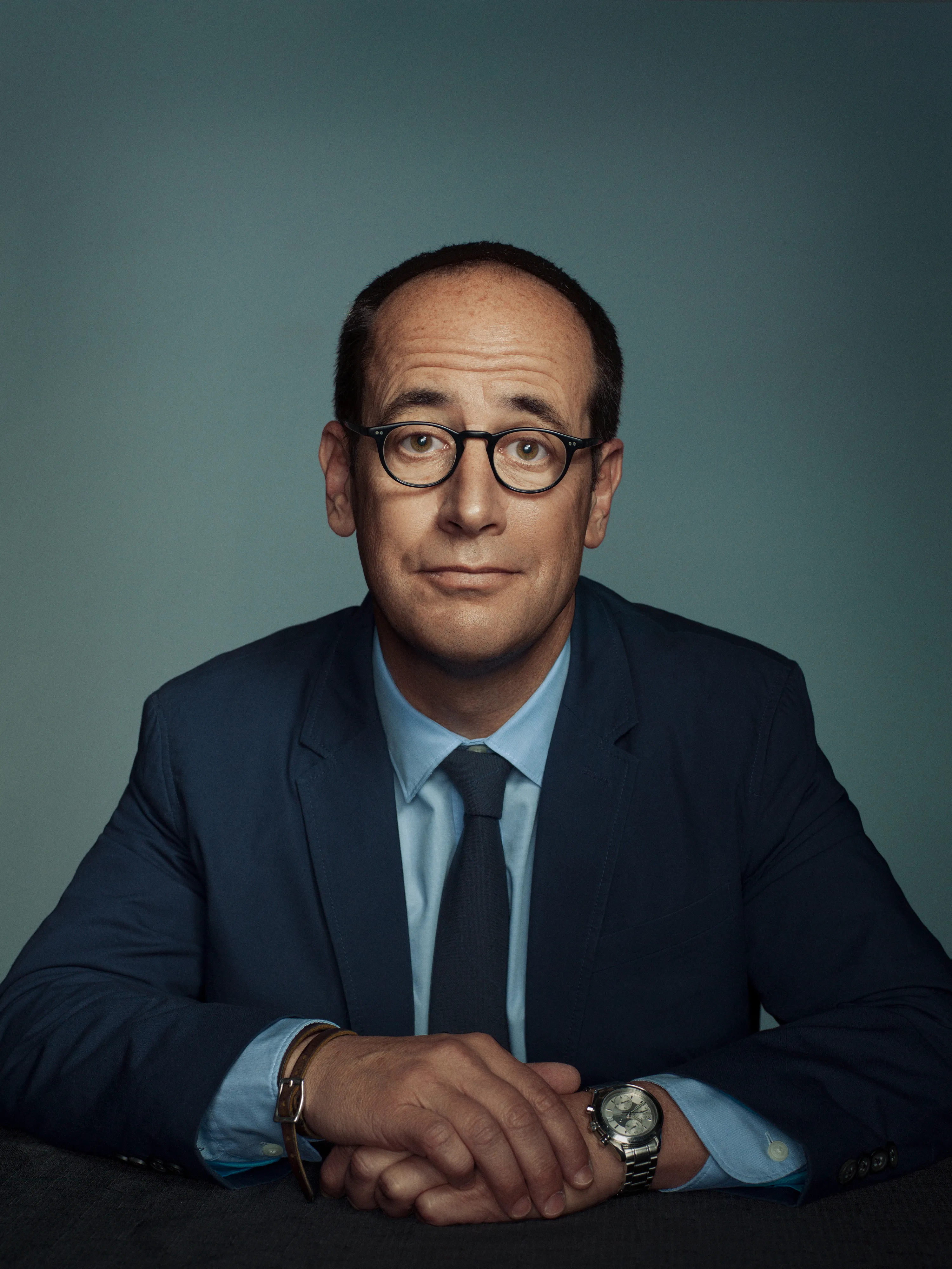 Portrait of gentleman with glasses sitting at a table