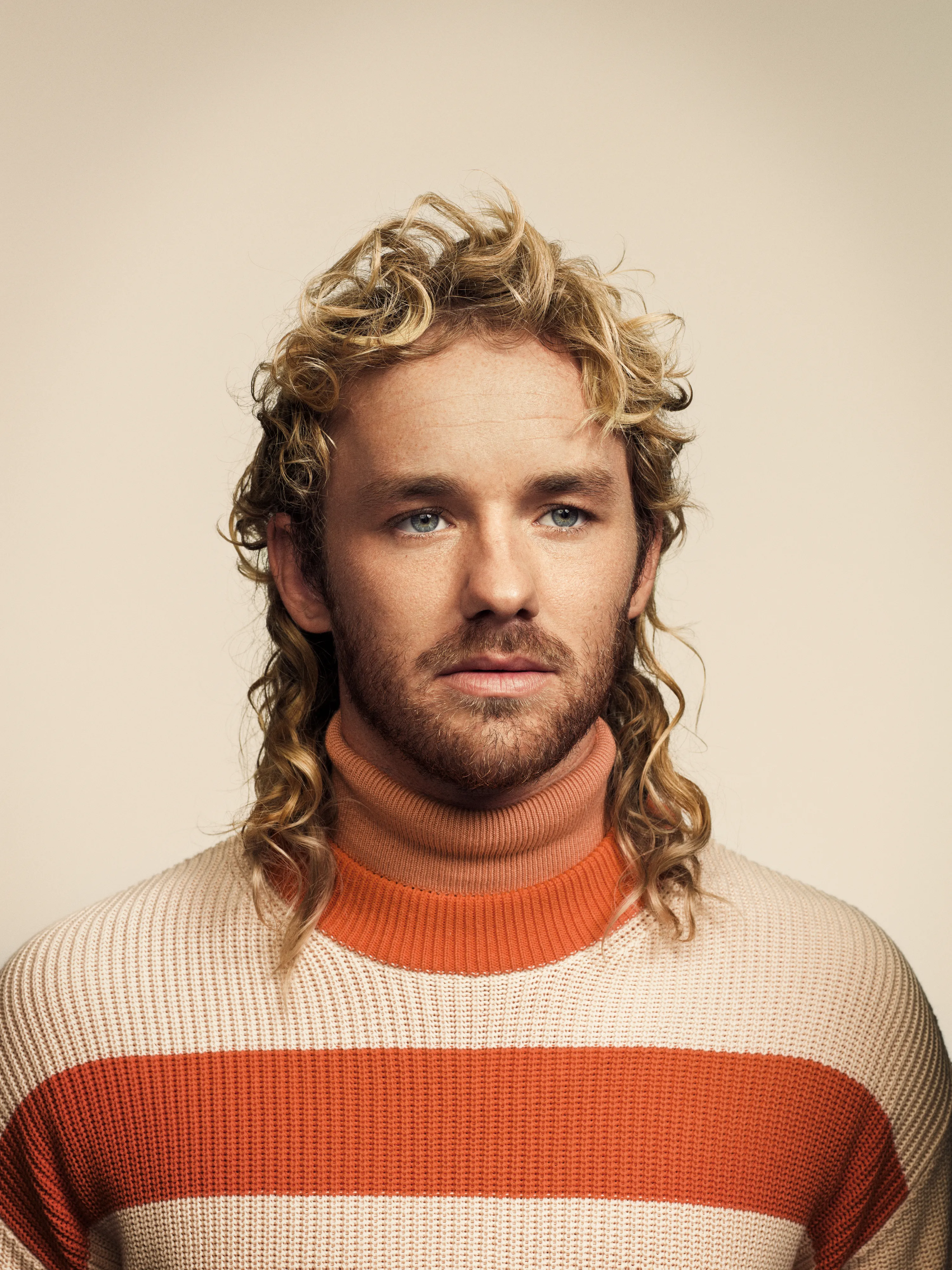 Man in striped turtleneck in front of seamless background