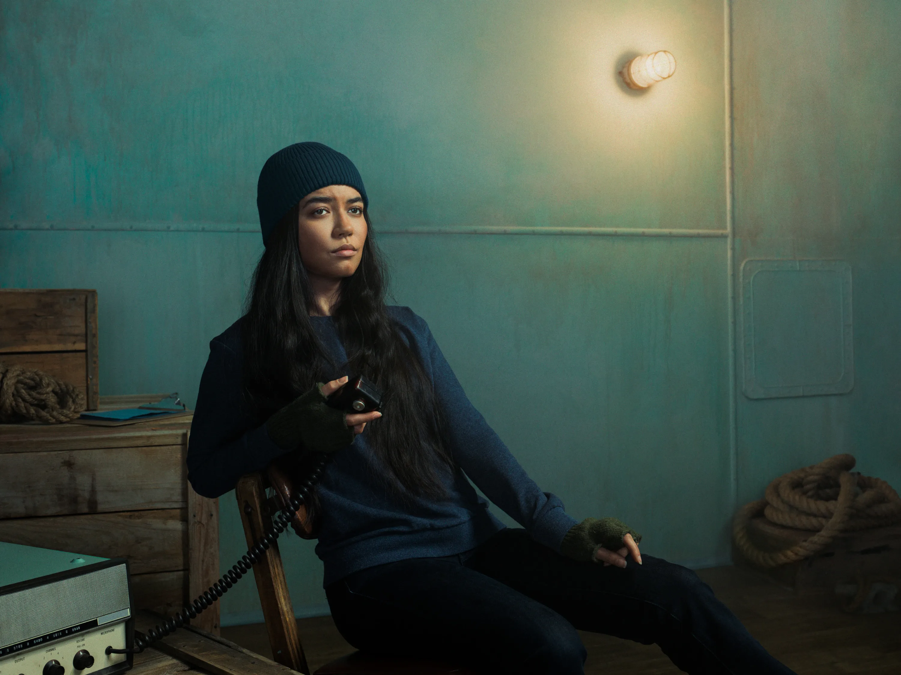 Woman in chair in beanie holding radio